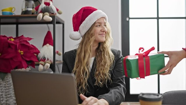 Young blonde woman business worker receiving christmas gift working at office