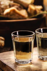 Cachaça, pinga, cana or caninha is the sugar cane brandy, a typical drink from Brazil, with a crackling appetizer in the background
