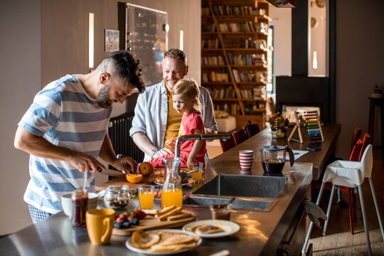Young gay family preparing breakfast in the kitchen