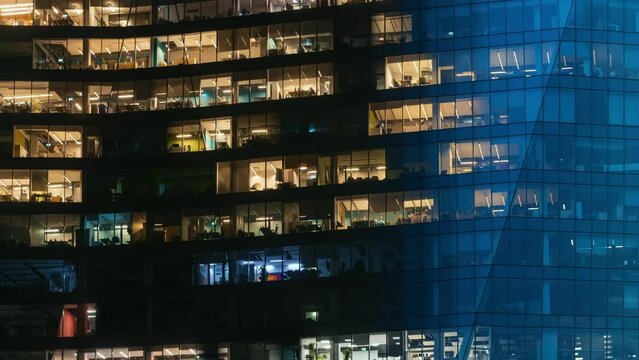 Day to night time-lapse timeslice effect blinking office windows lights, high-rise glass skyscraper business building in city downtown, work non-stop, turn on and off, endless work without breaks