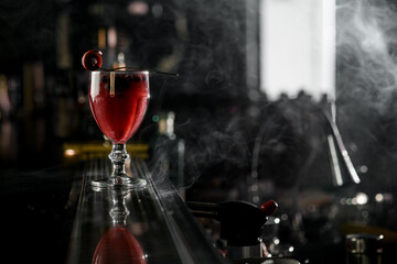 Red alcoholic cocktail with berries and Pastille in old fashioned glass on bar surface background