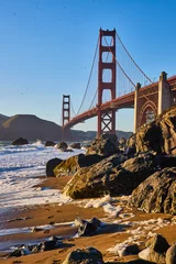 Papier Peint photo Pont du Golden Gate Shoe prints in sand coming from crashing waves at sunset with Golden Gate Bridge