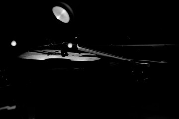 Violino de madeira em preto e branco sob luz direta. 