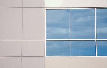 clouds reflect in windows of a building