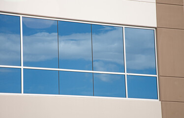 clouds reflect in windows of a building