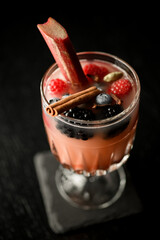 Appetizing strawberry cocktail in transparent glass, decorated with cinnamon stick and fresh...
