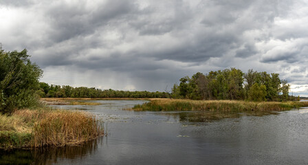 beautiful autumn landscape scenery with colors water clouds trees and grass
