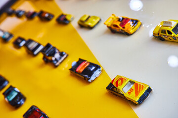 Black and yellow toy cars on shiny white and yellow background split diagonally