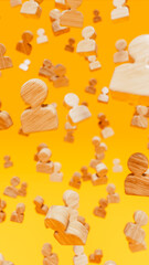 Wooden icons representing people float on orange stage, human resources and society theme