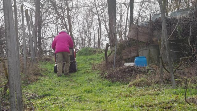farmer using crawler mini dumper to transport heavy machinery in the vine yard on the hill.