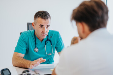 Experienced Doctor Analyzing Diagnostic Test Results and Advising Young Male Patient on Health Care...