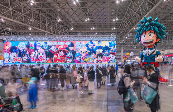 chiba, japan - dec 18 2022: At Jump Festa convention an inflatable character depicting Izuku Midoriya from the serie My Hero Academia welcomes attendees beside a banner featuring various manga heroes.