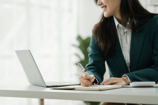 Financial institution worker female asian people, professionals engrossed in tasks. Business people diligently crunching numbers, advising clients, and securing deals from their desks.