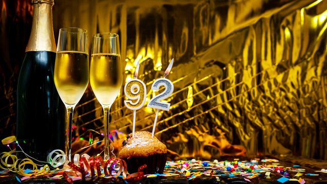 Copy space solemn background. Happy birthday golden background with number  92. Greeting card or postcard with a bottle of champagne with poured champagne in glasses.