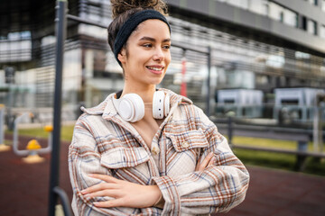 One young sporty woman with headphones happy smile stand outdoor