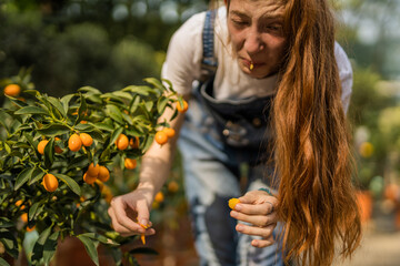 Ginger girl reacting after she tasted unripe tangerine that she picked up