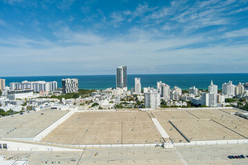 aerial shot of the Miami Beach Convention Center with blue ocean water and hotels and luxury...