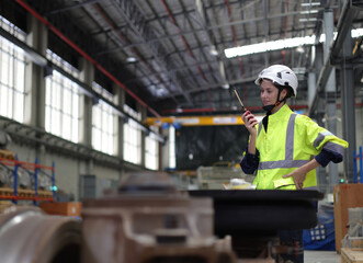 Portrait of a female electrical engineer using radio communication at the Rail train service station
