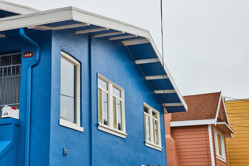 Detail of exterior blue home in white trim of San Francisco, USA on cloudy day