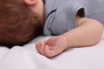 Newborn baby lying on white blanket, closeup
