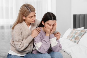 Fototapeta na wymiar Mother consoling her upset daughter in bedroom. Teenager problems