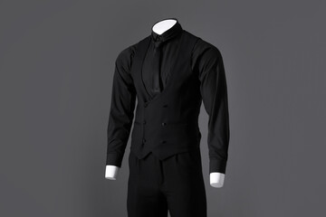 Male mannequin dressed in stylish black suit on grey background