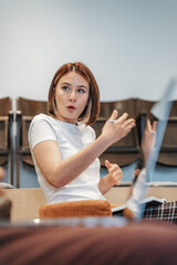 Smart business girl gesticulating with her hands while explaining something to her colleague