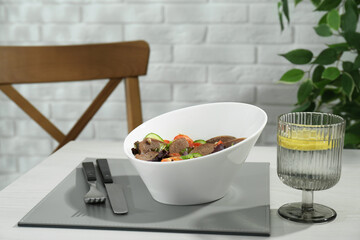 Delicious salad with beef tongue and vegetables served on white wooden table indoors. Space for text