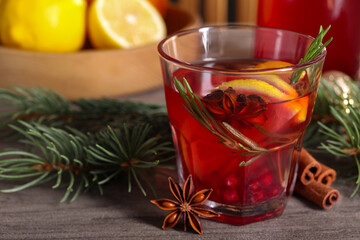 Aromatic punch drink and fir tree branch on wooden table, closeup. Space for text