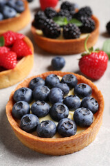 Tartlet with fresh blueberries on light grey table, closeup. Delicious dessert