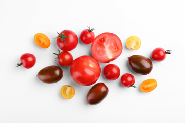 Flat lay composition with different whole and cut tomatoes on white background