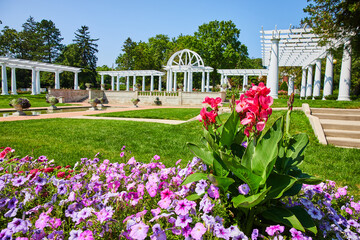 Gorgeous tall pink flowers and purple flowers in front of Lakeside Park pergola and fountains - Powered by Adobe