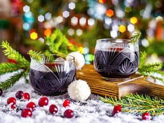 Two glasses of mulled wine with cranberries and christmas decoration