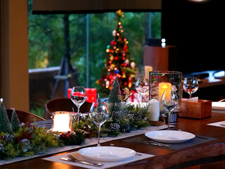 close up dining table setting for Christmas eve family party with deer decoration and wine glass