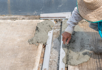 Worker pour cement a drainage ditch on road.