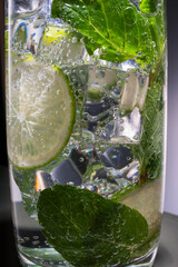 Mojito alcoholic cocktail, rum with mint ice, lime and tonic, close-up, macro
