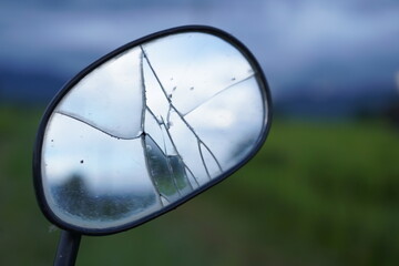 Broken motorcycle side mirror Beautiful rice field background on the mountain On the background of green mountains beautiful blue sky