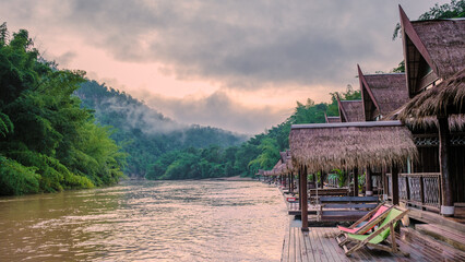 Tropical beach houses on the River Kwai in Thailand.Wooden floating raft house in river Kwai Kanchanaburi, Thailand at sunset - obrazy, fototapety, plakaty