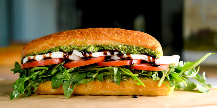 Caprese salad sandwich close-up view with arugula and pesto