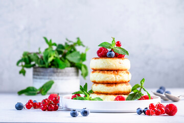 Thick pancakes with cottage cheese and blueberries, raspberries, red currants with fresh mint...