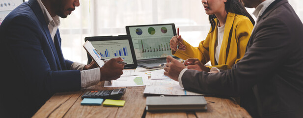 Group of Asian businessmen discussing business strategy Collaborate as a team during financial and marketing document discussions. Financial data analysis meeting and charts in the office.