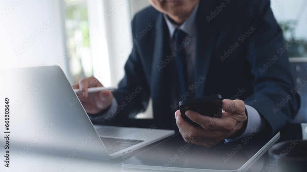 Poster businessman busy working at office, using mobile smart phone and working on laptop computer with dig