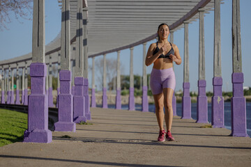 Latin girl runs by a pergola in a public park.