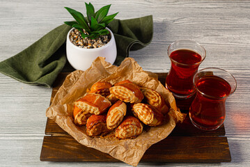Turkish sweets with nuts and Turkish tea on a wooden background. Huge pile of oriental cookies.