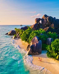 Washable wall murals Anse Source D'Agent, La Digue Island, Seychelles Anse Source d'Argent beach, La Digue Island, Seyshelles, Drone aerial view of La Digue Seychelles bird eye view, couple men and woman walking at the beach during sunset at a luxury vacation