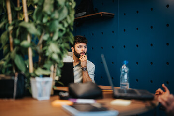 Dedicated entrepreneurs in a modern co-working space, focused on profit growth through online work. Browsing, searching, and targeting their audience for success.