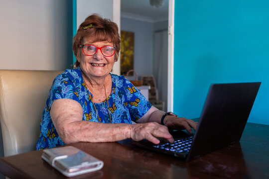 Happy older woman working on laptop at table