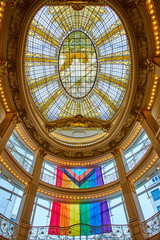 Obraz premium Rainbow flag dangling from Rotunda Roof interior view with stained glass ceiling
