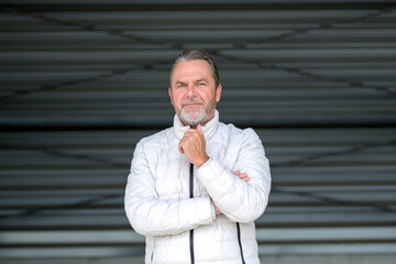 Man wearing a white winter jacket with a hand on his jacket