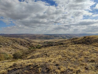 A steppe landscape in Ankara, Turkey. In the background there are tall skyscrapers and cityscape far away.